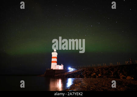 Das Gardur Leuchtturm 1897 auf der Halbinsel Reykjanes in Island gebaut an der Südküste mit der Nordlichter erscheinen über den Wolken. Stockfoto