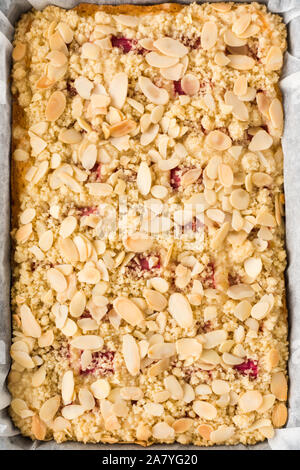 Blick von oben auf die hausgemachten Rhabarber Kuchen in einem Backblech mit Backpapier ausgekleideten bröckeln. Stockfoto