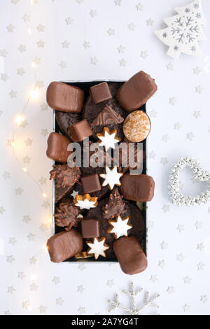 Deutsche Lebkuchen Sortiment in cookie Zinn mit Weihnachten Dekoration und Lichterketten. Ansicht von oben. Stockfoto