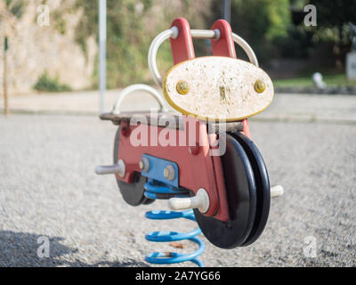 Metallfeder mit einem bunten Motorrad in einen Kinderspielplatz Stockfoto