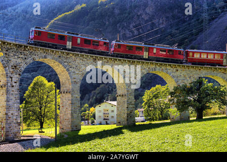 Schweizer Bergbahn Bernina Express führt die Spirale von Brusio Viadukt Stockfoto