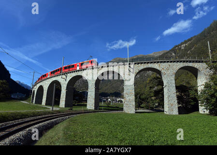 Schweizer Bergbahn Bernina Express führt die Spirale von Brusio Viadukt Stockfoto