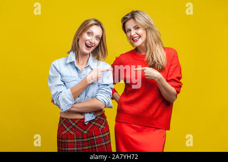 Beste Freunde scherzen. Porträt von zwei glückliche Frauen in legere Kleidung zeigen und an jedem anderen Lachen, an der Kamera suchen, unbeschwerten weibliche Freundschaft. Stockfoto