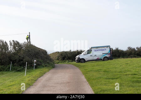 BT Openreach Techniker Arbeiten in der Höhe auf einem Telegrafenmast in einem ländlichen Gebiet, Cornwall, Großbritannien Stockfoto