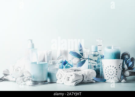 Schöne blau weiß spa Komposition. Verschiedene kosmetische Produkte mit brennenden Kerzen und Blumen auf dem Tisch bei hellen Hintergrund. Skin Care setting. Modus Stockfoto