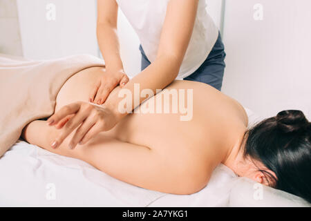 Frau erhält allgemeine zurück Massage im Spa Center. Masseur Rücken-, in der Nähe Stockfoto