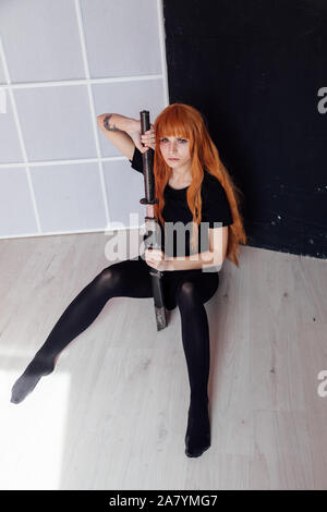 Modische Frau mit roten Haaren anime Japan Schwert Stockfoto