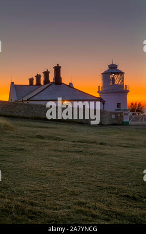 Swanage, Dorset England Schöne orange leuchten, kurz vor Sonnenaufgang, an Amboss Point Lighthouse Stockfoto