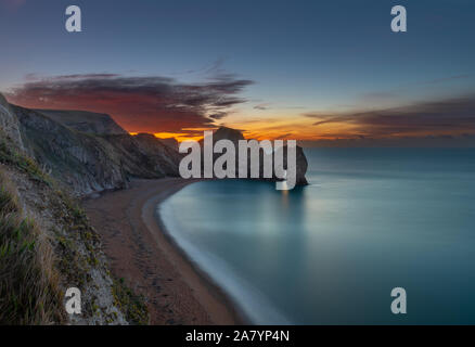 Durdle Door Dorset England wunderschönen Sonnenaufgang über der Küste von Dorset, mit Blick auf Durdle Door, wahrscheinlich das bekannteste Wahrzeichen der Jurassic Coast Stockfoto