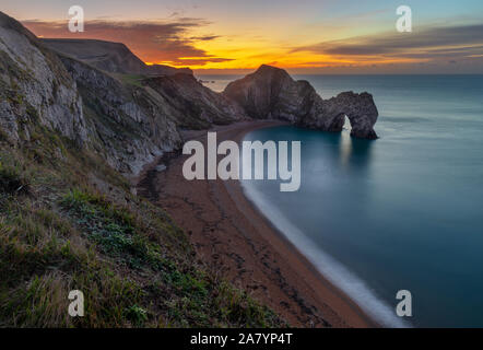 Durdle Door Dorset England wunderschönen Sonnenaufgang über der Küste von Dorset, mit Blick auf Durdle Door, wahrscheinlich das bekannteste Wahrzeichen der Jurassic Coast Stockfoto