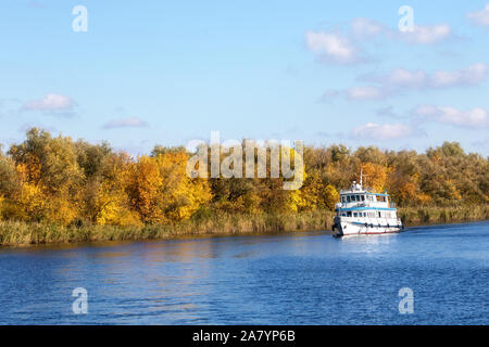 Bild eines kleinen weissen Dampfer entlang eine große Herbst Fluss Stockfoto