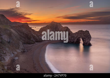 Durdle Door Dorset England wunderschönen Sonnenaufgang über der Küste von Dorset, mit Blick auf Durdle Door, wahrscheinlich das bekannteste Wahrzeichen der Jurassic Coast Stockfoto