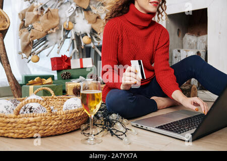 Zugeschnittenes Bild der jungen Frau mit Kreditkarte Einkaufen online für Weihnachtsgeschenke Stockfoto