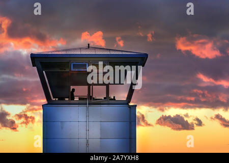 Eine Air Traffic Control Tower mit der Silhouette der männlichen traffic controller, Wetter, Island. Stockfoto