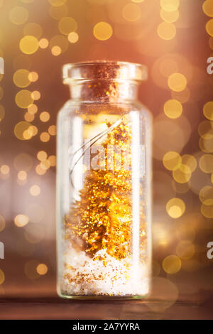 Miniatur Gold Weihnachtsbäume in Glas Spielereien, die in Form von kleinen Flaschen sind, xmas Postkarte Konzept Stockfoto