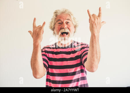 Glücklich und verrückt Senior alter Mann mit Rock'n Roll Handzeichen - alternative Reifen kaukasischen Portrait Leute haben Spaß-jugendlicher pensionierter Mann mit weissen Bac Stockfoto