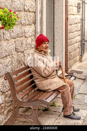 Street Portrait von einem älteren Mann in einem roten Strickmütze Tempio Pausania, Sassari, Sardinien, Italien. Stockfoto