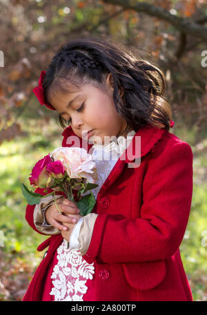 Kleines Mädchen im roten Kleid, Weihnachten und mit Blätter im Herbst Stockfoto