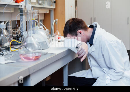 Männliche Wissenschaftler schläft in der medizinischen Chemie Labor Stockfoto