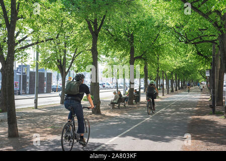 Strandvagen Stockholm, Aussicht im Sommer von Menschen Radfahren in Strandvägen, einer von Bäumen gesäumten Avenue auf Östermalm in Stockholm, Schweden. Stockfoto