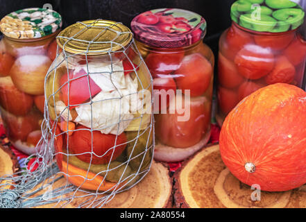 Eingemachtes Gemüse in Gläsern. Eingelegte Gurken und Tomaten. Stockfoto