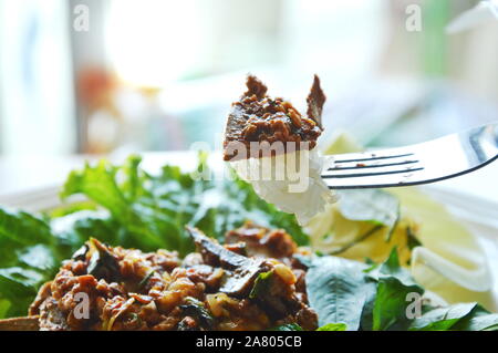 Würzige Schweineleber Salat mit klebrigem Reis Stab in der Gabel Stockfoto