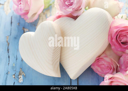 Holz- Herzen und Rosen auf einem blauen Hintergrund Stockfoto