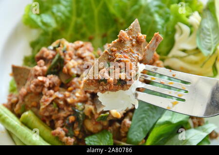 Würzige Schweineleber Salat mit klebrigem Reis Stab in der Gabel Stockfoto