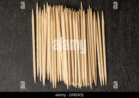 Menge ganze Holz braun Zahnstocher flatlay am grauen Stein Stockfoto