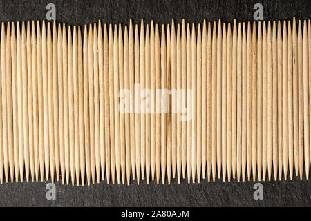 Menge ganze Holz braun Zahnstocher flatlay am grauen Stein Stockfoto