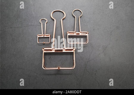 Rose Gold Metall Clips von 3 auf den grauen Schreibtisch Stockfoto