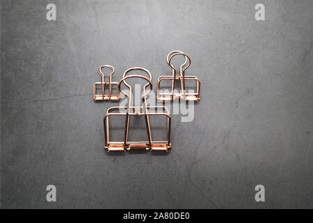 Rose Gold Metall Clips von 3 auf den grauen Schreibtisch Stockfoto