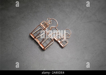 Rose Gold Metall Clips von 3 auf den grauen Schreibtisch Stockfoto