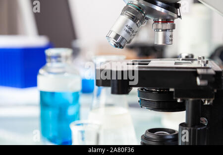 Medizinische oder wissenschaftliche Forschung Ausrüstung und Mikroskop in einer Laborumgebung mit Flaschen und Röhrchen Stockfoto