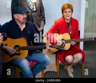 Dalkeith, Schottland, Großbritannien. 5. November 2019. Erster Minister Nicola Sturgeon trat Owen Thompson, SNP Kandidat für Midlothian, zur Kampagne in Dalkeith an einem dalkeith Community Hub, wo Sie lokale Künstler und Musiker. Pic; Nicola Sturgeon nahmen an einer Gitarre jamming Session mit lokalen Musikern. Iain Masterton/Alamy Leben Nachrichten. Stockfoto