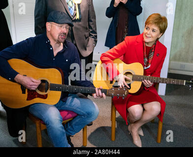 Dalkeith, Schottland, Großbritannien. 5. November 2019. Erster Minister Nicola Sturgeon trat Owen Thompson, SNP Kandidat für Midlothian, zur Kampagne in Dalkeith an einem dalkeith Community Hub, wo Sie lokale Künstler und Musiker. Pic; Nicola Sturgeon nahmen an einer Gitarre jamming Session mit lokalen Musikern. Iain Masterton/Alamy Leben Nachrichten. Stockfoto