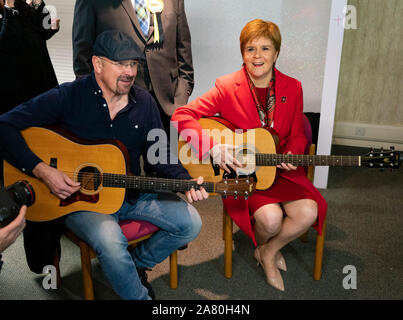 Dalkeith, Schottland, Großbritannien. 5. November 2019. Erster Minister Nicola Sturgeon trat Owen Thompson, SNP Kandidat für Midlothian, zur Kampagne in Dalkeith an einem dalkeith Community Hub, wo Sie lokale Künstler und Musiker. Pic; Nicola Sturgeon nahmen an einer Gitarre jamming Session mit lokalen Musikern. Iain Masterton/Alamy Leben Nachrichten. Stockfoto