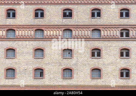 Die aussenfassade eines Ziegelfabrik oder kommerzielle Gebäude mit Bogenfenstern in einem niedrigen Winkel anzeigen Stockfoto