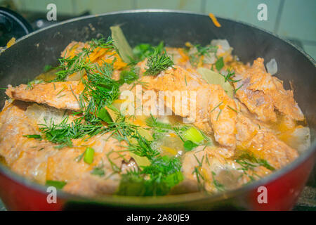 Fleisch mit Zwiebeln, Karotten, Dill und Lorbeerblatt ist geschmort in eine Pfanne geben. Home Kochen Stockfoto