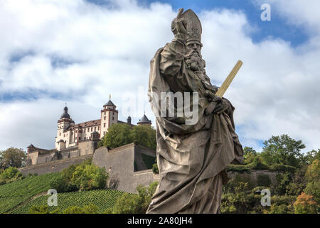 Statue von St. Kilian (St. Kilianus) auf Heiligen "Brücke über den Main und die Festung Marienberg im Hintergrund, Würzburg, Bayern, Deutschland Stockfoto