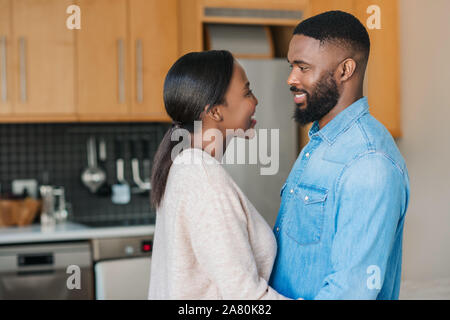 Lächelnden jungen afrikanischen amerikanischen Paar ständigen liebevoll zusammen zu Hause Stockfoto