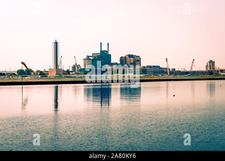 Blick auf die Royal Docks und die silberstadt Skyline mit Tate und Lyle Werk spiegelt sich auf der Themse Kanal, im Osten von London, England. Stockfoto