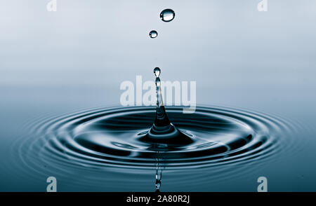 Wassertropfen fallen ins Wasser macht einen perfekten Droplet-Sprung Stockfoto