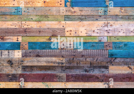 Grunge Holz Hintergrund in natürlichen Farben mit Rot, Grün und Blau. Landhausstil rauhe Bretter mit Nägeln, Bohrungen und einer Vielzahl von Farben und Texturen. Stockfoto