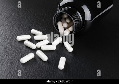 Nahrungsergänzungsmittel Kapseln auf schwarzem Hintergrund closeup Stockfoto