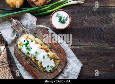 Frische hausgemachte gebratene Kartoffelpuffer latkes auf rustikalen hölzernen Schneidebrett. Traditionelle jüdische Speisen für Hannukah Feier. Ansicht von oben. Stockfoto