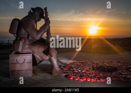 Sun Rise an der Tommy Statue am Morgen des Tag der Erinnerung im Seaham Grafschaft Durham. Ein Service der Erinnerung wird an der Statue gehalten, um die gefallenen Soldaten zu erinnern. am Mittwoch, den 11. November 2015, County Durham, England. Eine Hommage an die vor der Erinnerung Tag Gefallen am Freitag durch die Erinnern, Sie Fonds eines riesigen Mohn, mit Kieselsteinen vom Strand erstellt, rot lackiert und legte am Fuß der 1101 (aka Tommy) Statue, ein neun-und-ein-halb Fuß Skulptur eines müden Soldaten durch Ray Lonsdale. Sun Rise an der Tommy Statue am Morgen des Tag der Erinnerung im Seaham Grafschaft Durham. Ein Service Stockfoto