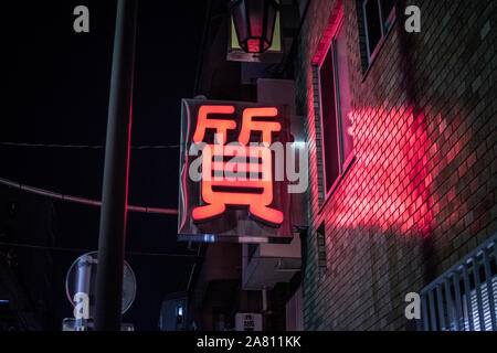 Tokio bei Nacht, Neon japanische Schriftzeichen kanji Symbol für Pawn Shop Stockfoto