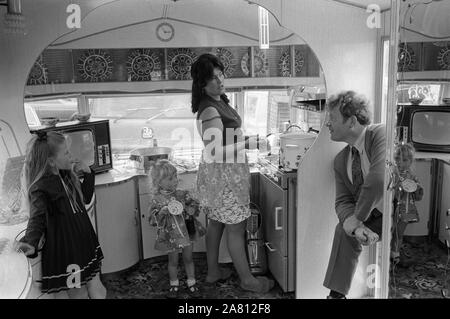 Innenraum des Travellers Zigeuner Caravan 1970S. Im Küchenbereich gibt es kein fließendes Wasser, da es als Pech gilt. Mutter zwei Tochter und Vater beim Derby Day Pferderennen, Epsom Downs England. 1974 HOMER SYKES Stockfoto