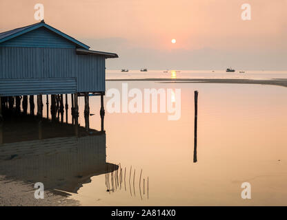 Marine bei Sonnenaufgang mit traditionellen Holzhaus auf Stelzen und ruhige rosa Himmel und Meer, Prek Svay, Koh Rong Insel, Kambodscha. Stockfoto